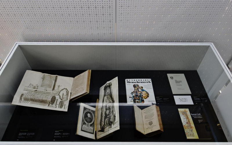 Verschiedene Bücher aufgeschlagen in einer Vitrine