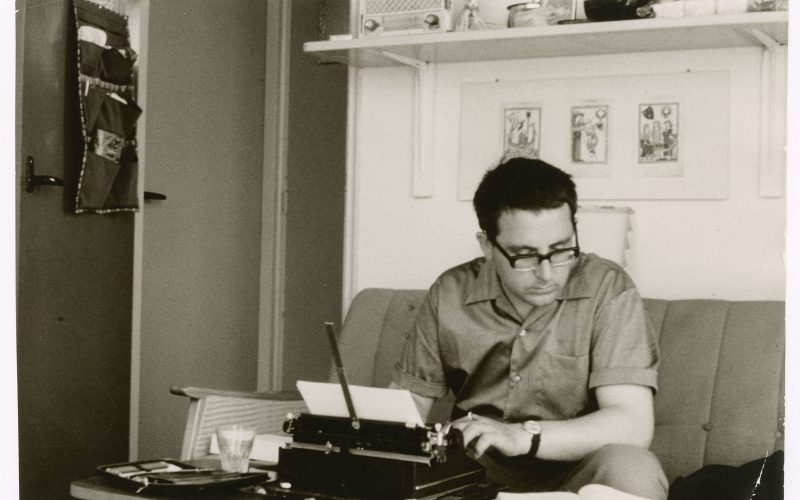 Theo Lutz sits on the couch in a study and works at the typewriter.