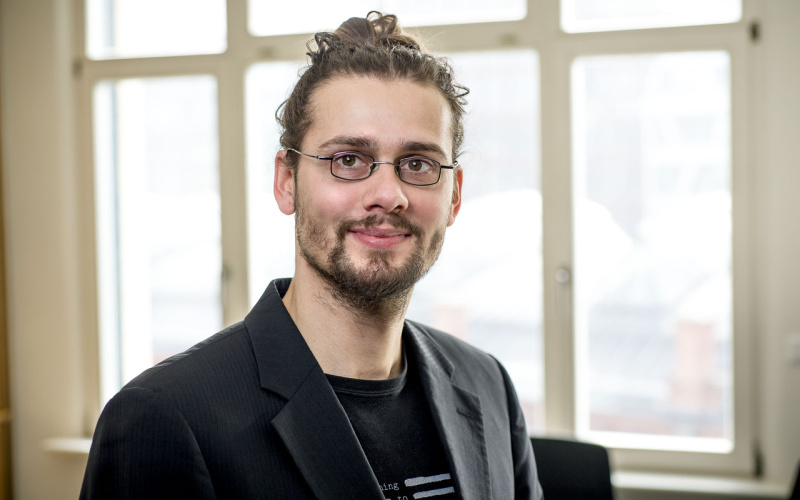 Portrait Rainer Rehak vor hellem Hintergrund