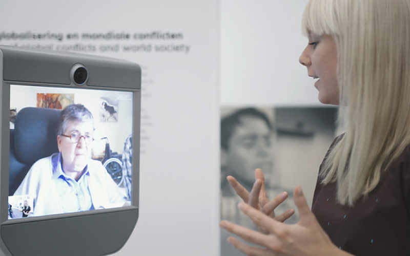 Das Bild zeigt einen Führungsroboter im VanAbbe Museum und eine Museumsführerin. 