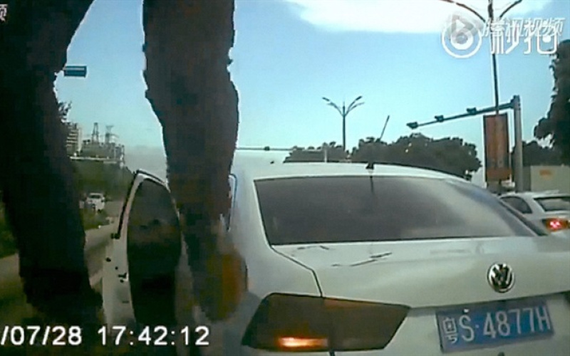 Bild einer Überwachungskamera: Zwei Beine, dahinter ein Taxi
