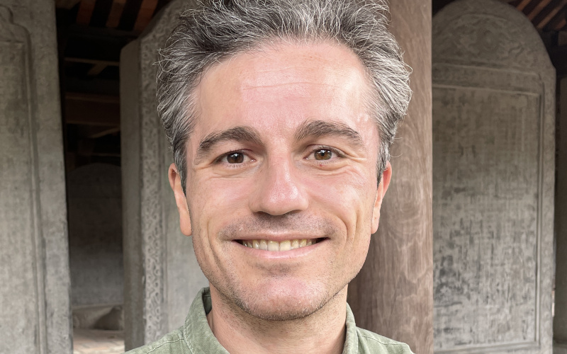 A man in a green linen shirt with short gray hair