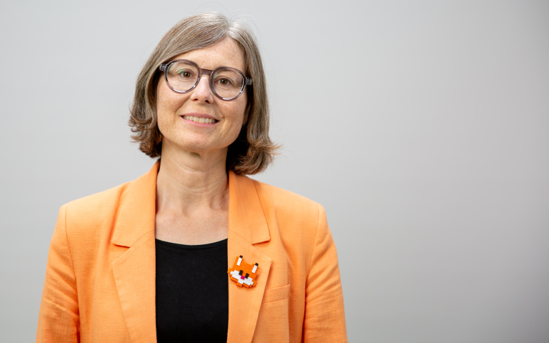 Sitzende Frau mit hellen Haaren und Brille