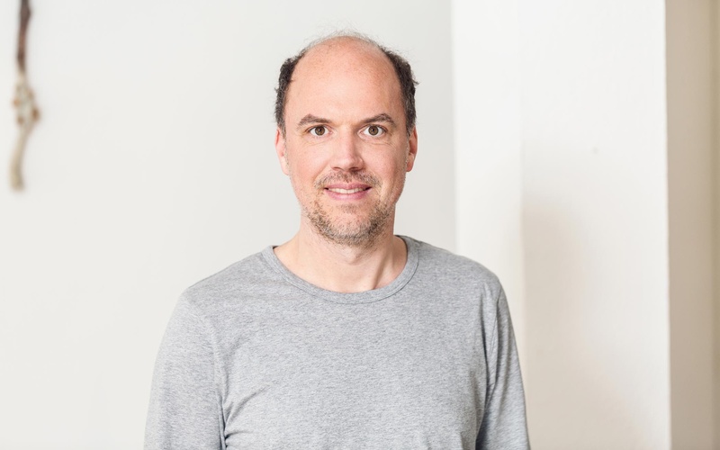Porträt einer Person vor weißem Hintergrund.