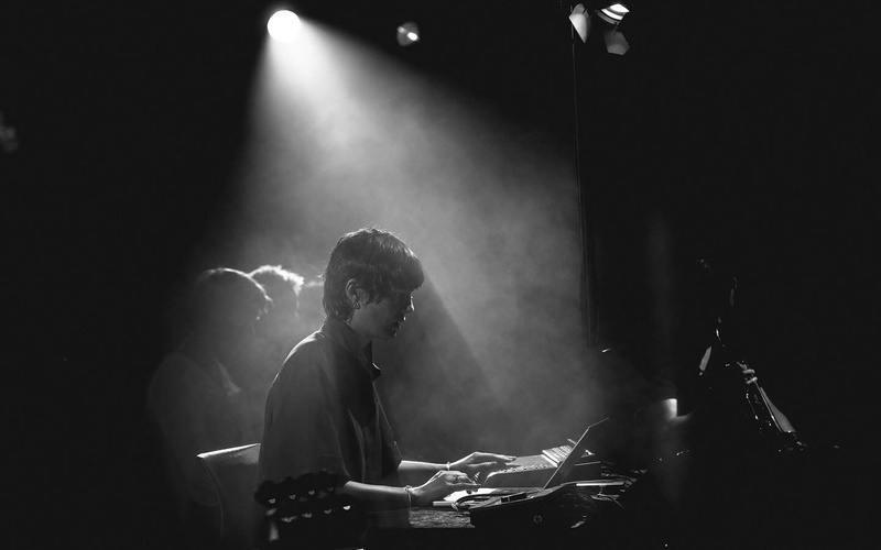 The portrait photo of a person in the beam of a stage lamp can be seen. 