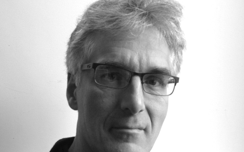 A portrait photo of Karl Sims is shown. 