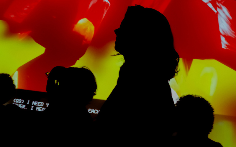 Eine Personensilhouette vor einer gelb-orangenen Projektion