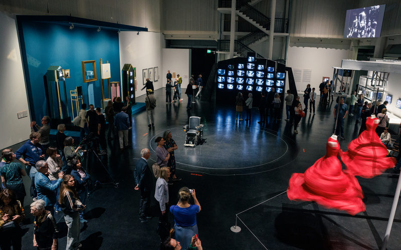 Das Foto zeigt einen mit Menschen und Exponaten gefüllten Ausstellungsraum. 