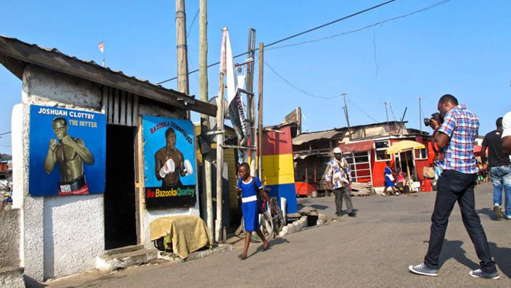A boy walks to a building with posters