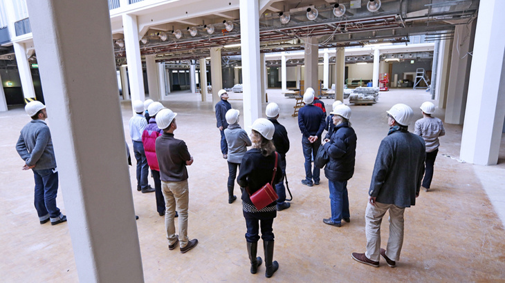 People with building-site helmets in atrium