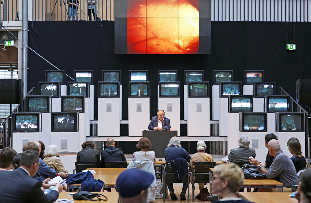 Ein Mann sitzt vor mehreren Bildschirmen