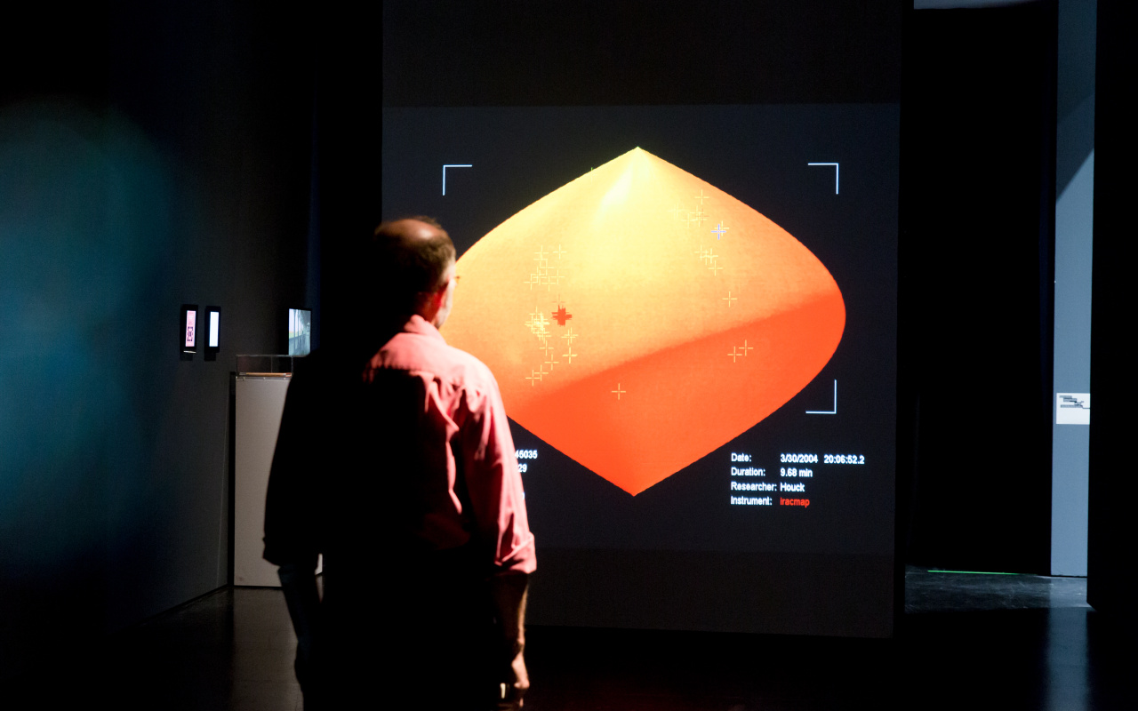 A man stands in front of a representation of the room with an infrared camera