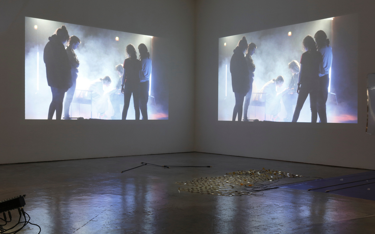 Doppelte Installation mit Menschen in Nebel, projieziert an Wand