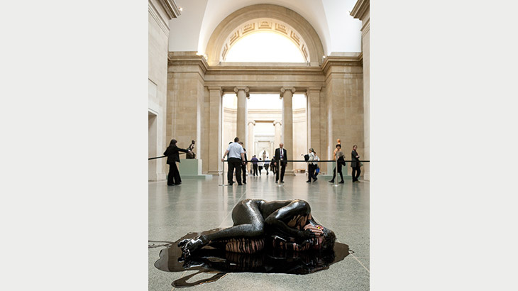 A person doused with Oil is lying on the floor