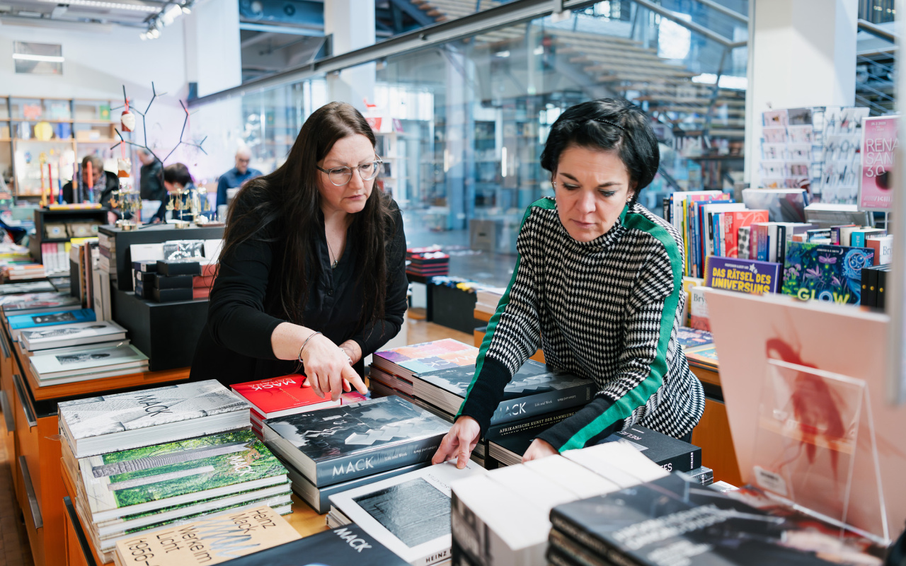 Zwei Frauen beim Richten der Bücher im ZKM Shop.