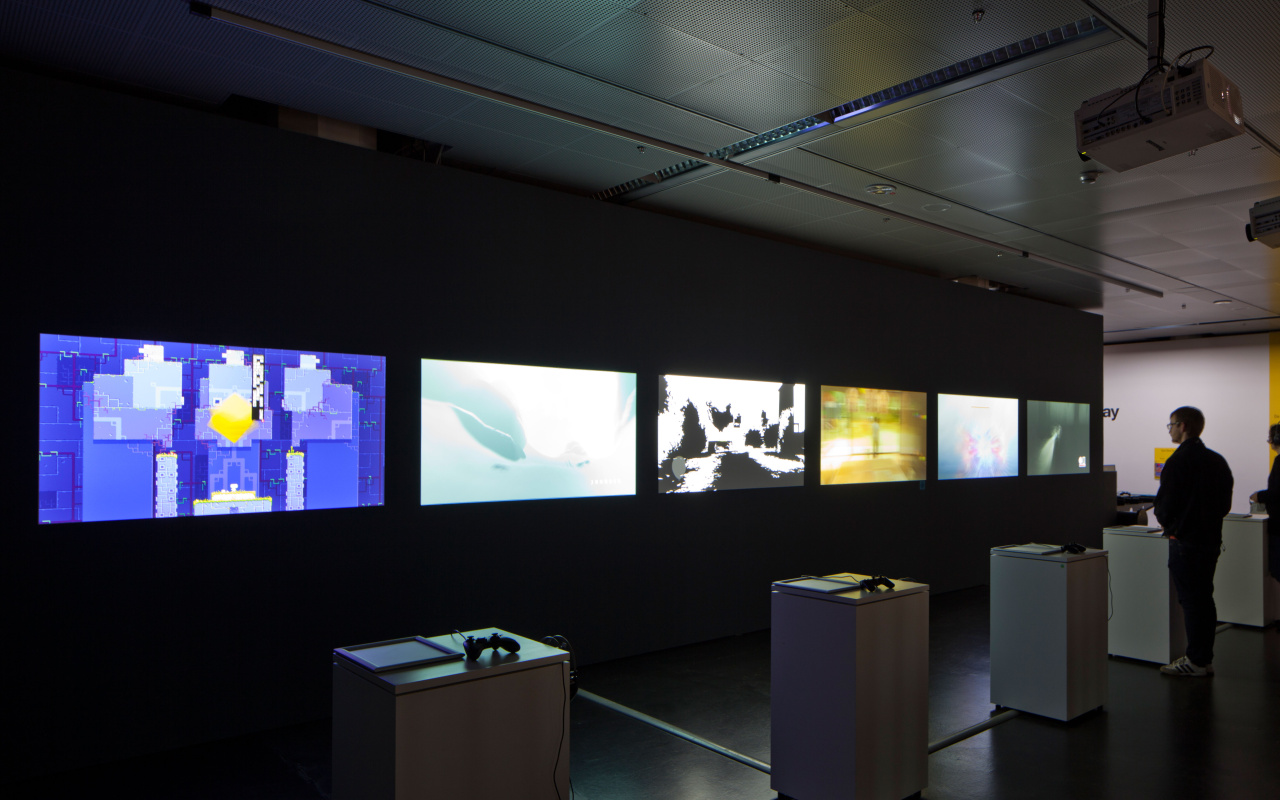 Several computer games on screen. One person playing at a game console.