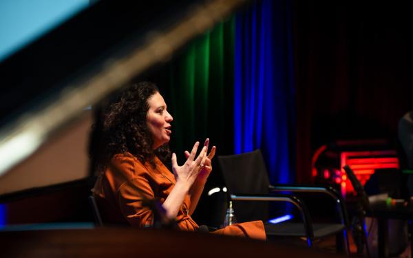 Noa Frenkel in conversation, her hands gesturally supporting her speech.