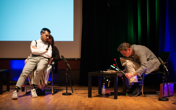 Óscar Escudero sits on the lap of Belenish Moreno-Gil. You listen interested to Manos Tsangaris music, which he creates with sticks