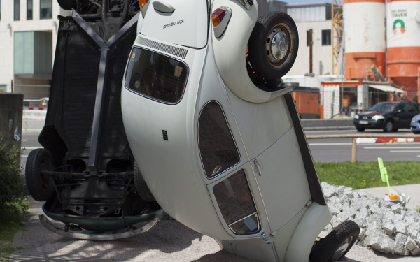 A white VW beetle standing on his head