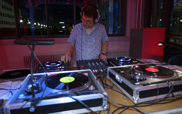 Ein Mann mit Kopfhörern vor einem DJ-Set
