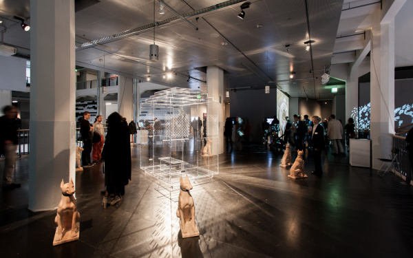 Menschen im Ausstellungsraum. Im Vordergrund eine Hunde-Plastik