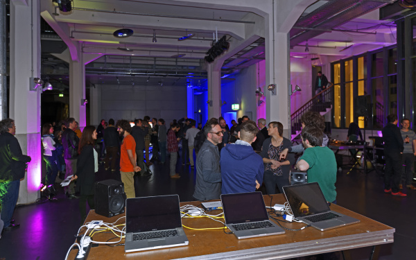 Eine Menschenmenge vor drei Laptops