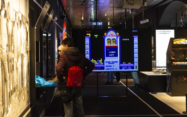 Zwei Menschen stehen vor einem Bildschirm im Ausstellungsraum »zkm_gameplay«.