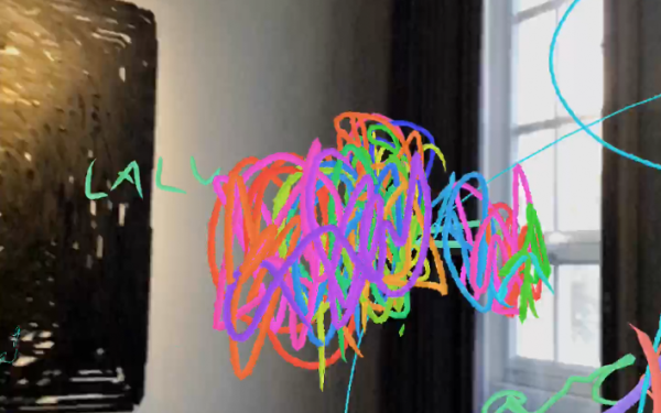 Zu sehen ist ein eine Ecke eines Raums. In den virtuellen Raum rein ist mit bunten Stiften ein Wollknäuel-artige Form gemalt worden.