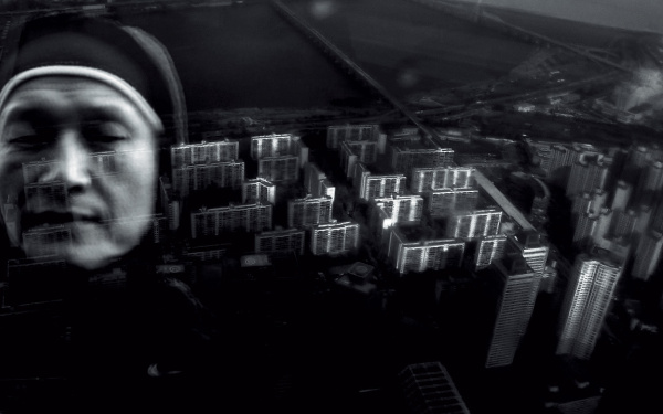 Die Schwarzweiß-Collage zeigt eine Nonne vor einer Vogelperspektive auf Wolkenkratzer. 