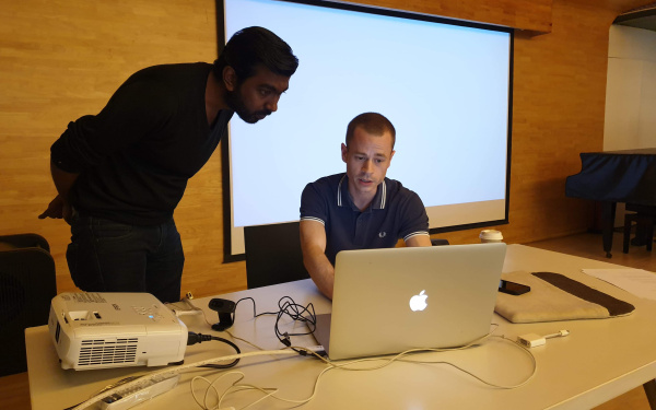 Zu sehen sind zwei Männer vor einem Laptop im Rahmen eines Workshops des ZKM im Goethe-Institut in Mumbai.