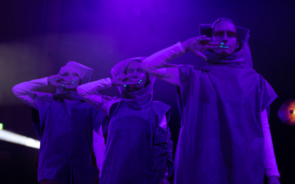 You can see three people, standing next to each other, wrapped in purple light