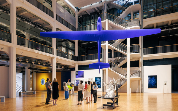 A large blue airplane is hanging in the atrium of the ZKM.