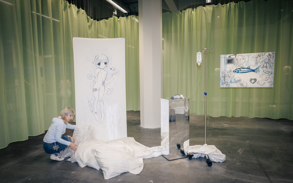 The image shows a person setting up an installation.