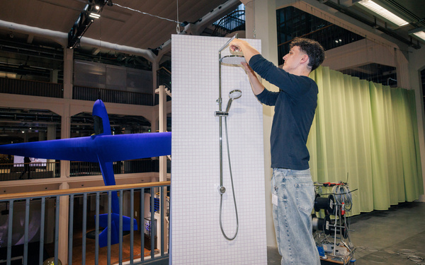The image shows a person setting up an installation.