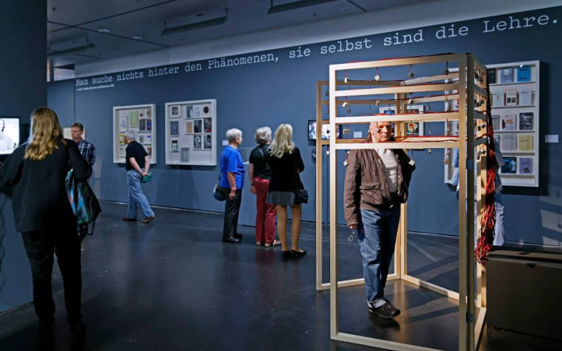 People standing in the exhibition space and look at the works