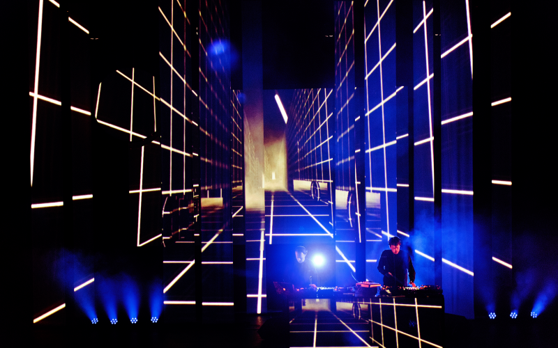 DJ duo on stage, lighting effects in the background