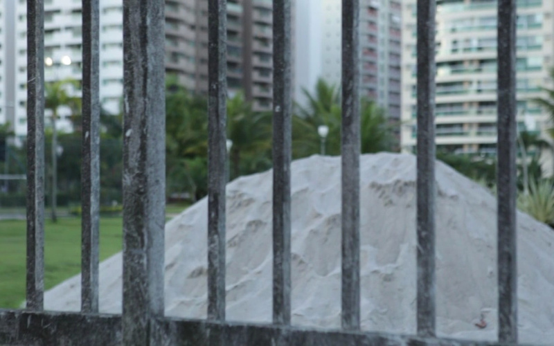 A pile of sand behind a fence