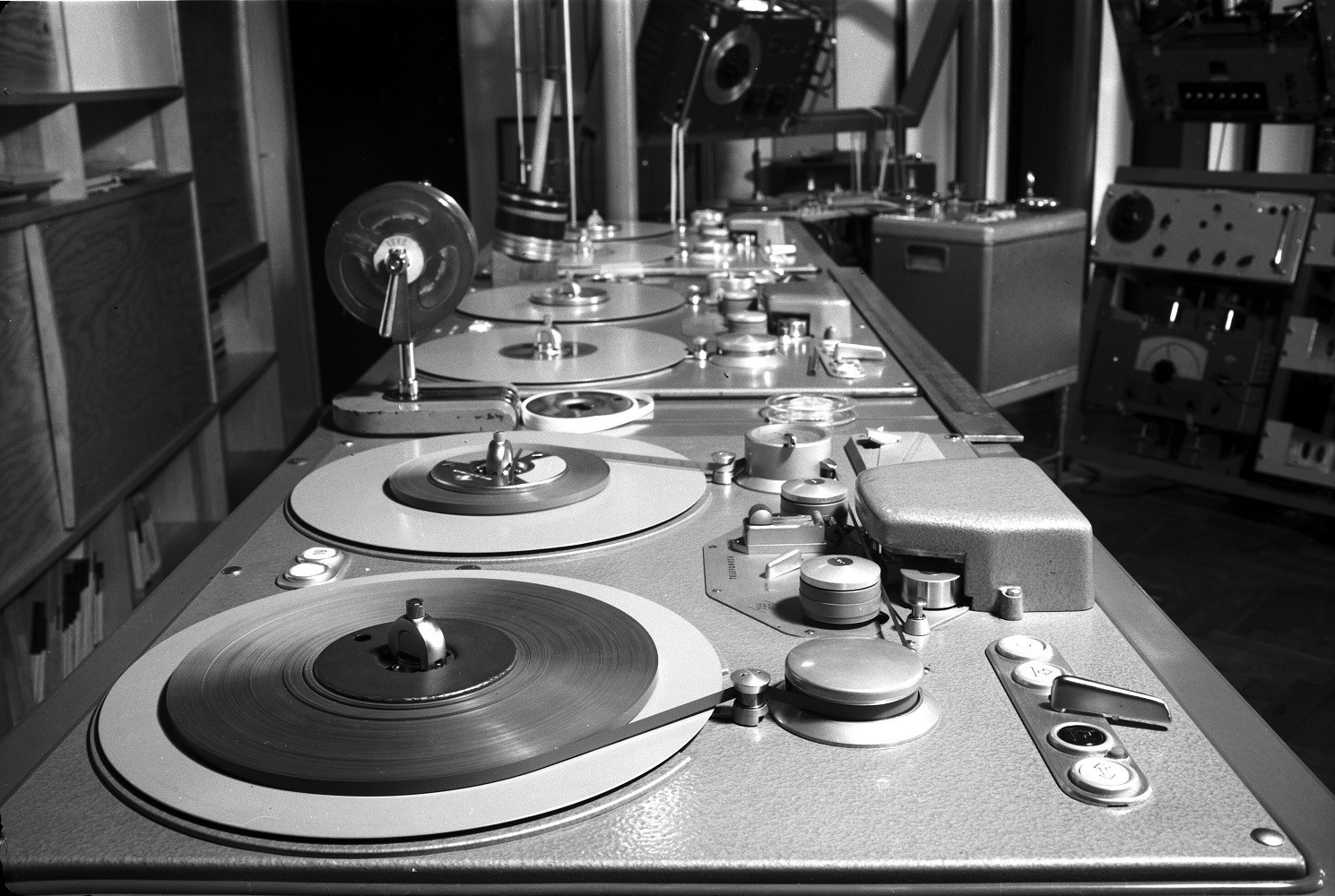 The black and white image shows an old mixing console. 