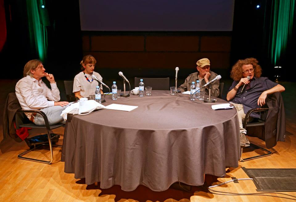 Four persons at a table with microphones