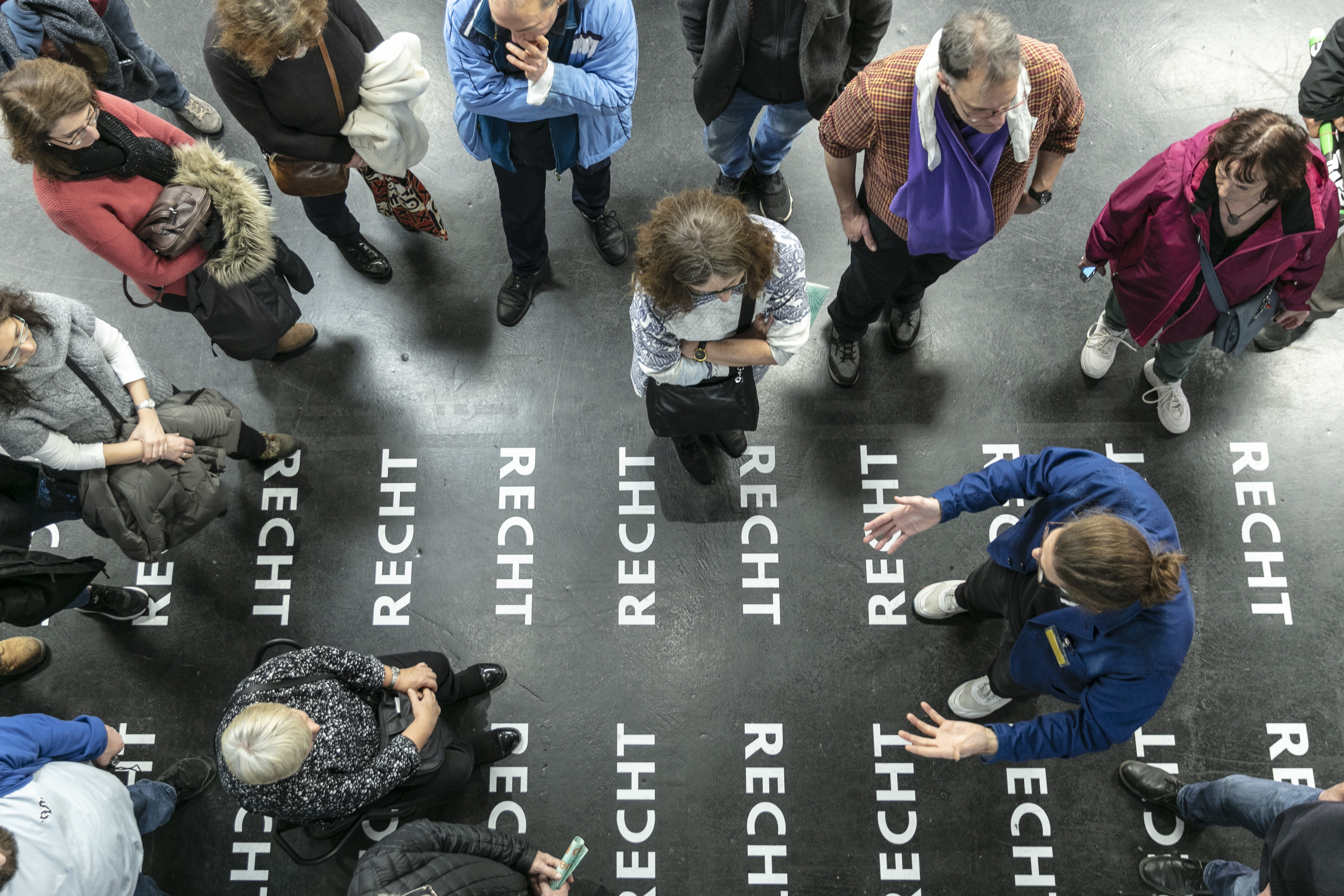 Viele Menschen von oben fotografiert bei einer Führung durch die Ausstellung »respektive Peter Weibel« am ZKM.