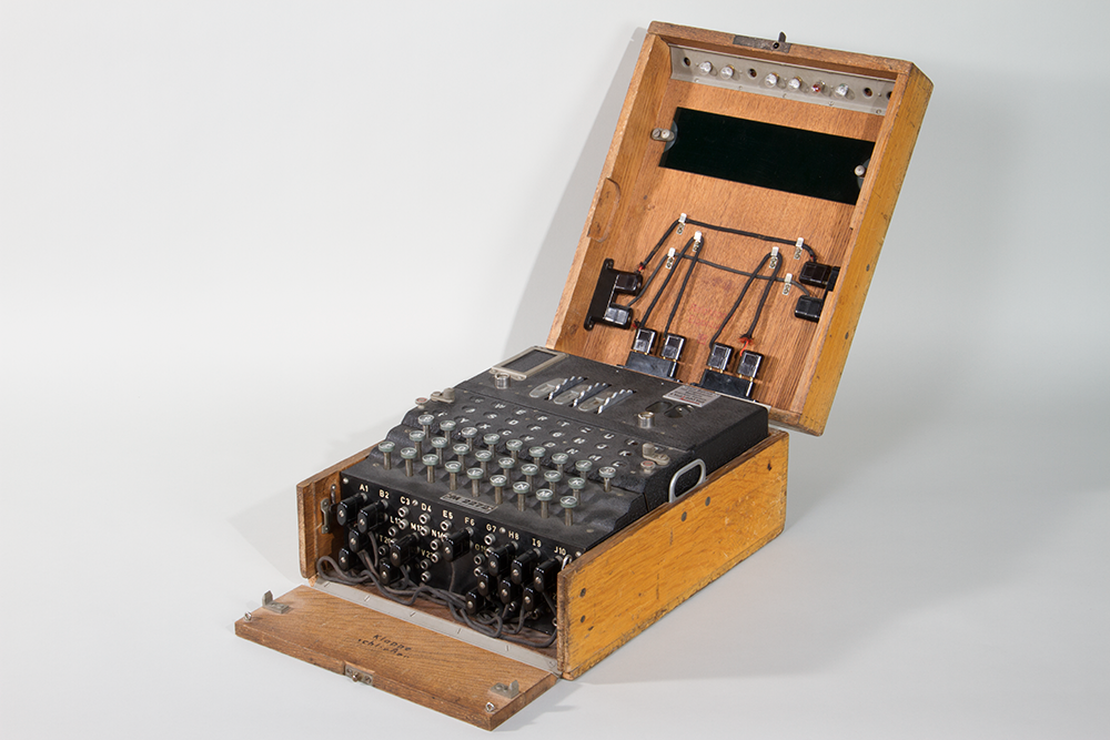 Black apparatus with buttons and cables in a wooden box