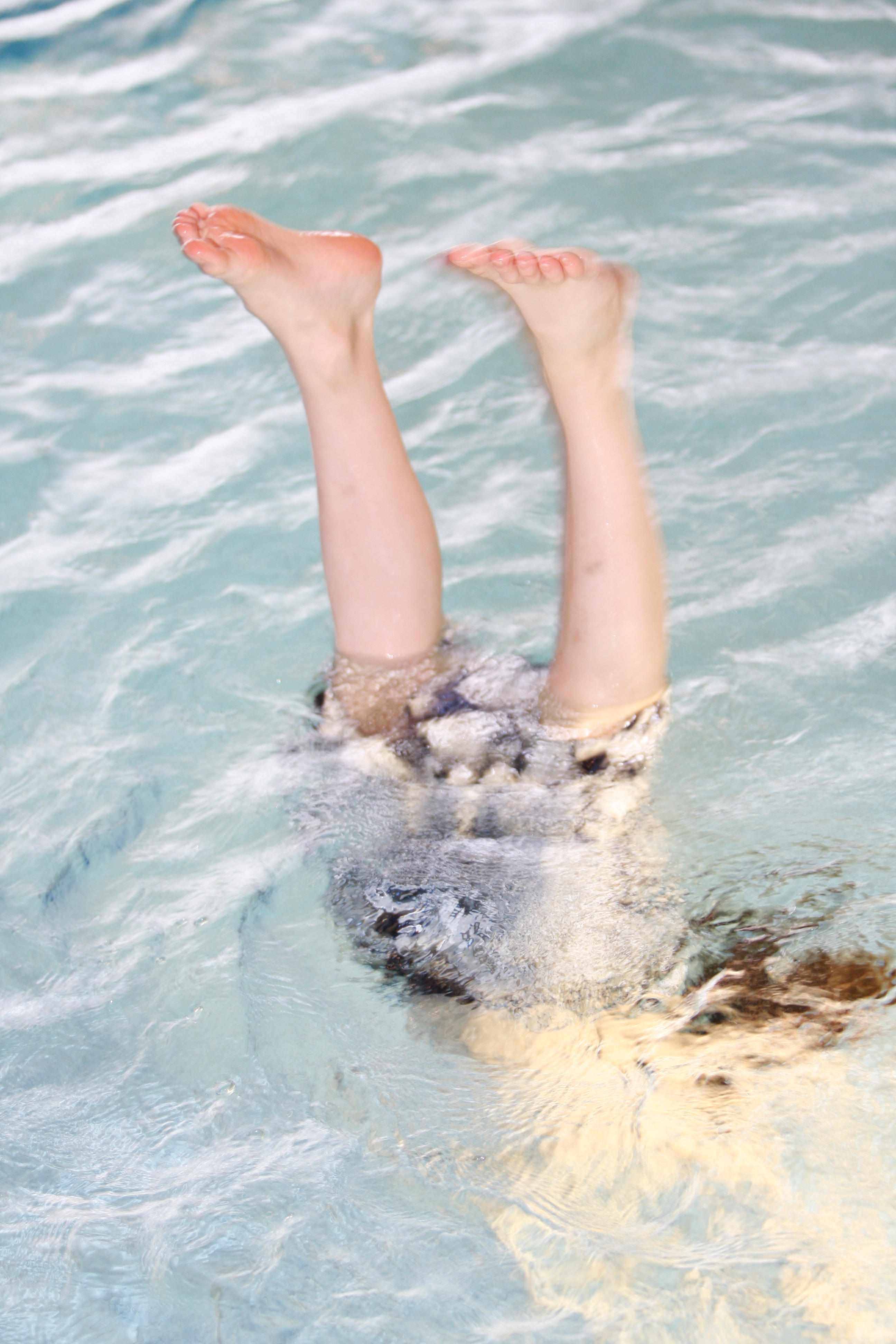 The photo shows two children's feet looking out of the water. 