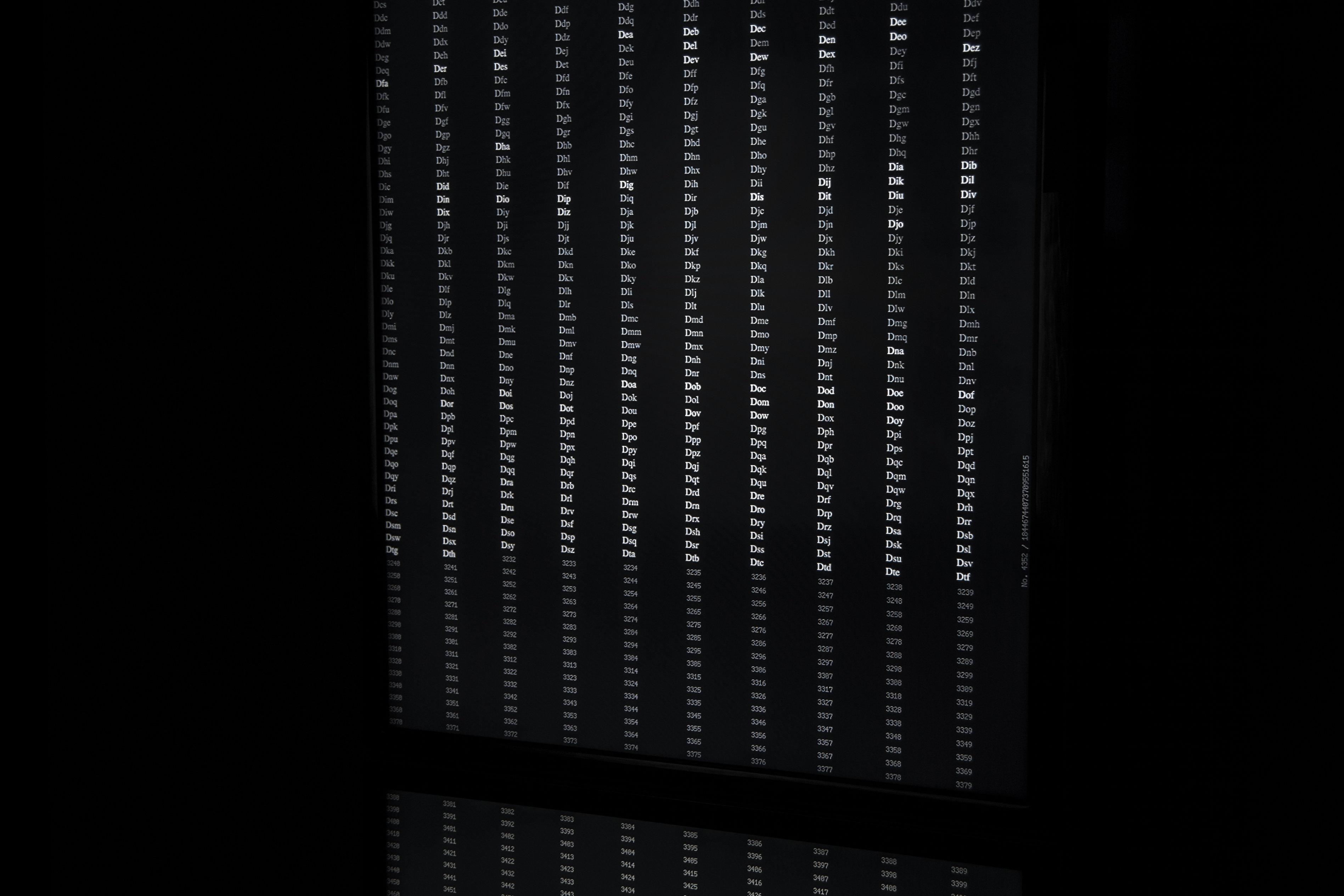 The photo shows a black room with different data columns of letters and numbers.