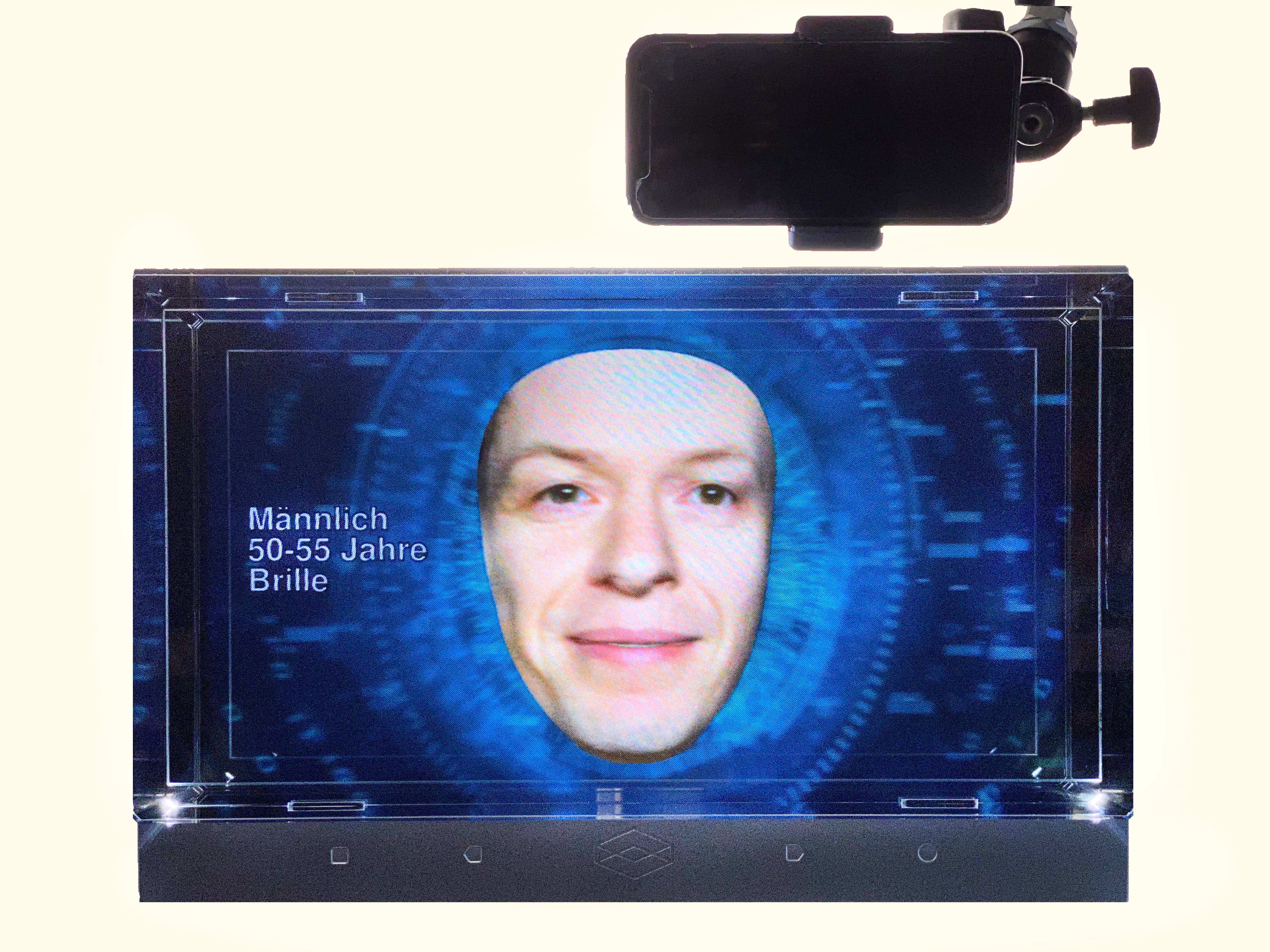 A small screen shows a face against a blue background.