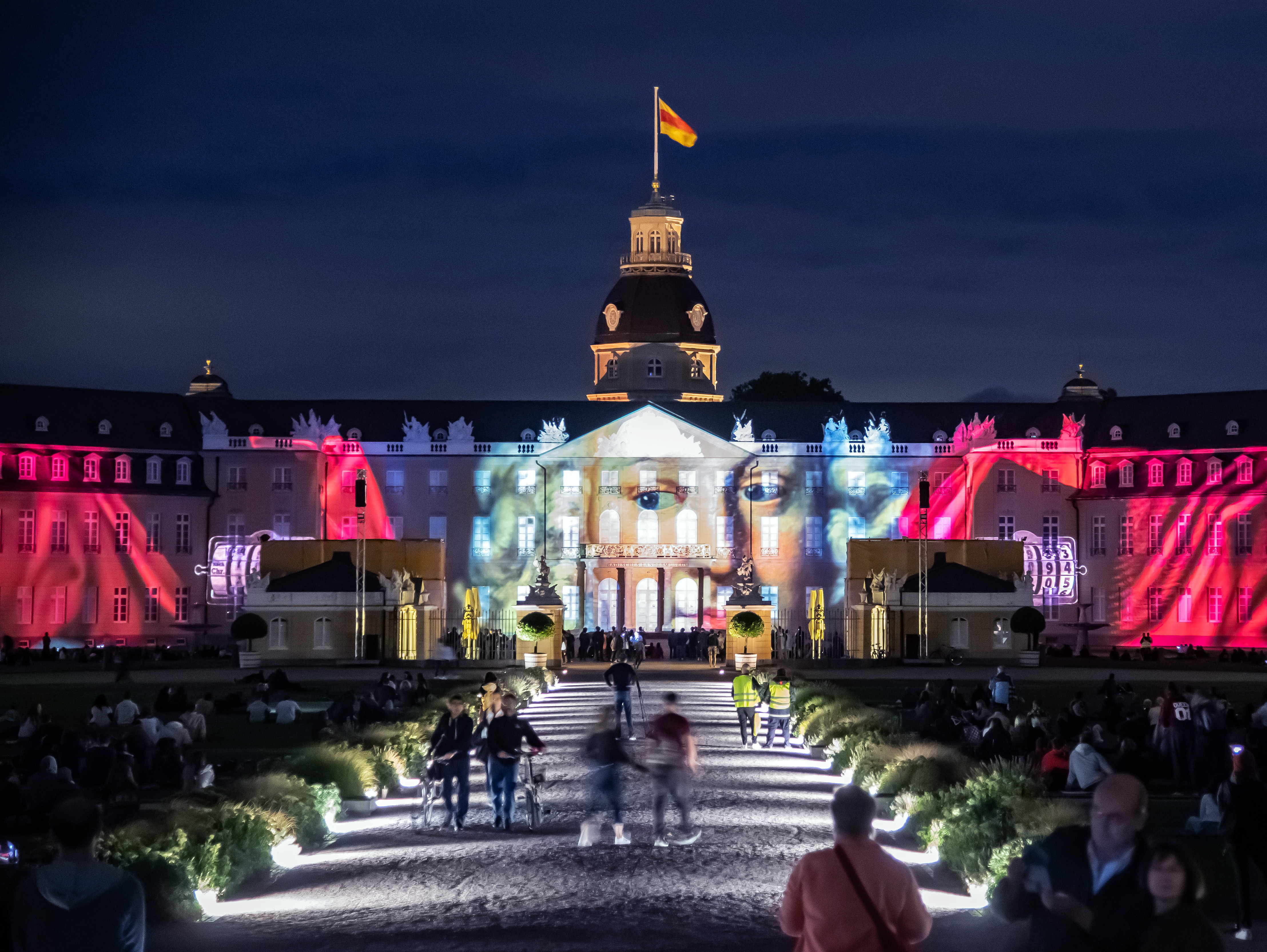 Foto eines bunten Projection Mappings bei Nacht auf dem barocken Karlsruher Schloss.