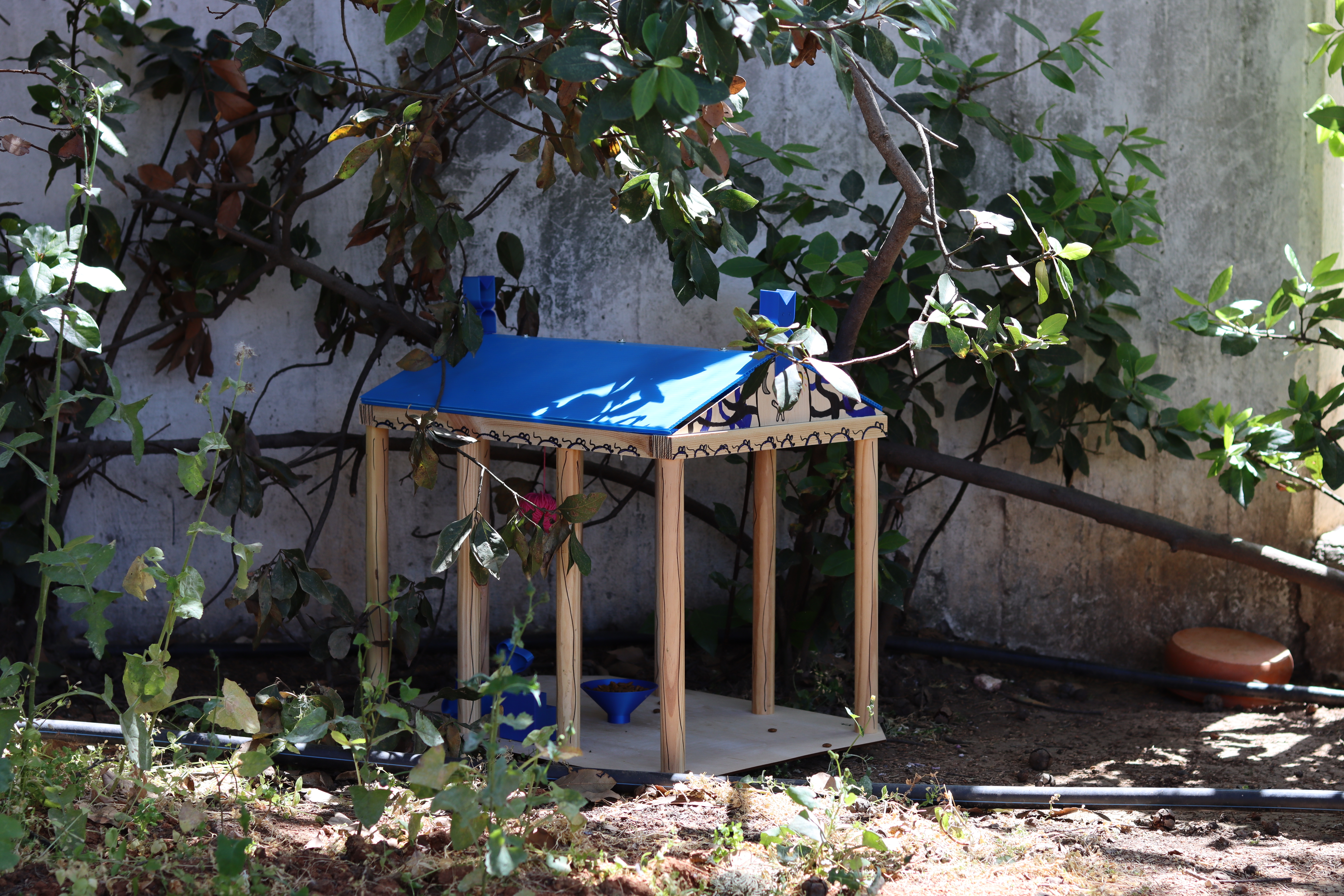 In the picture you can see a beautiful section of a garden, where there is a small house made of sticks.