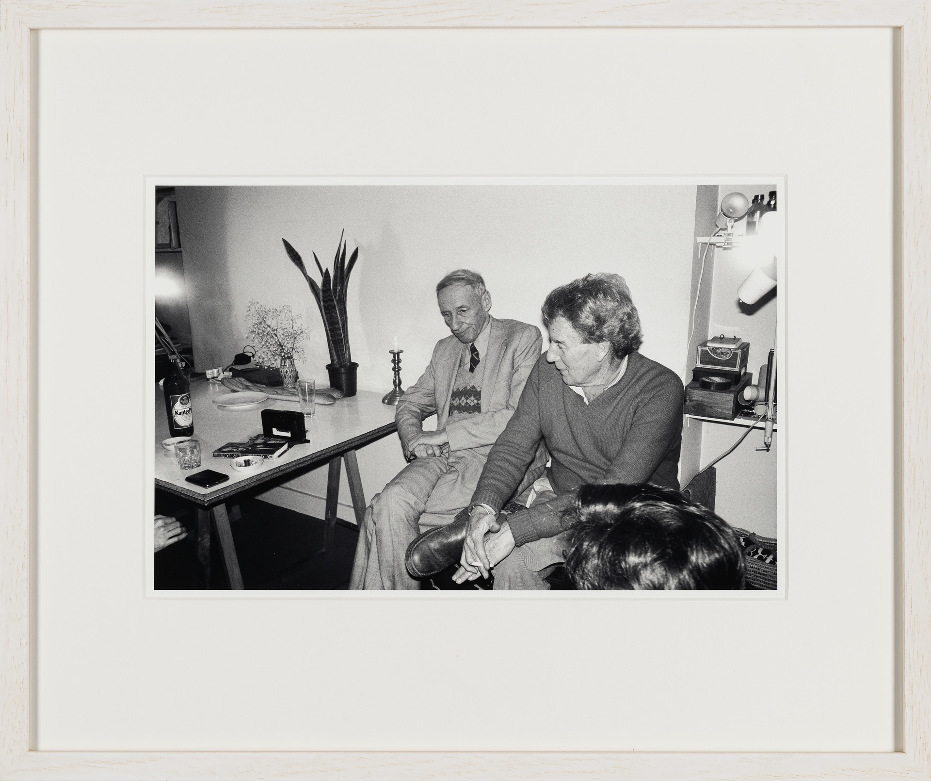 Enjoying a visit by William Burroughs. The two best friends sitting on Brion’s Tanger chest, holding important documents of the two. The shock of hair in the foreground could be Terry Wilson’s who often came over from London whenever WSB was visiting