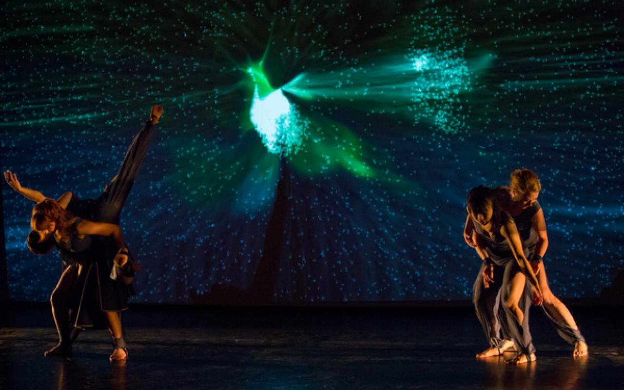 Four dancers in the foreground, in the background a starry sky with a bird-like structure.