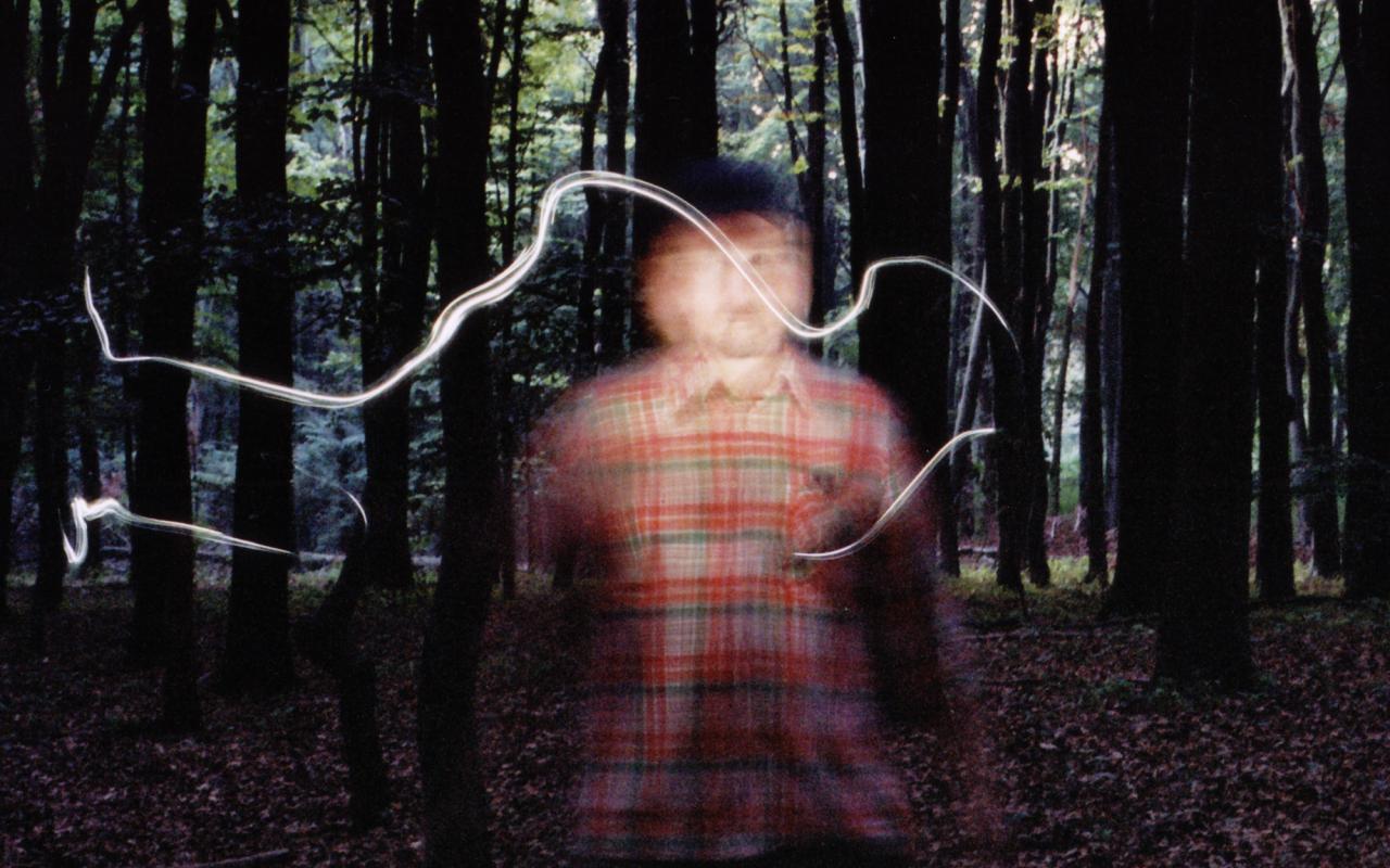 A blurry man standing in the forest