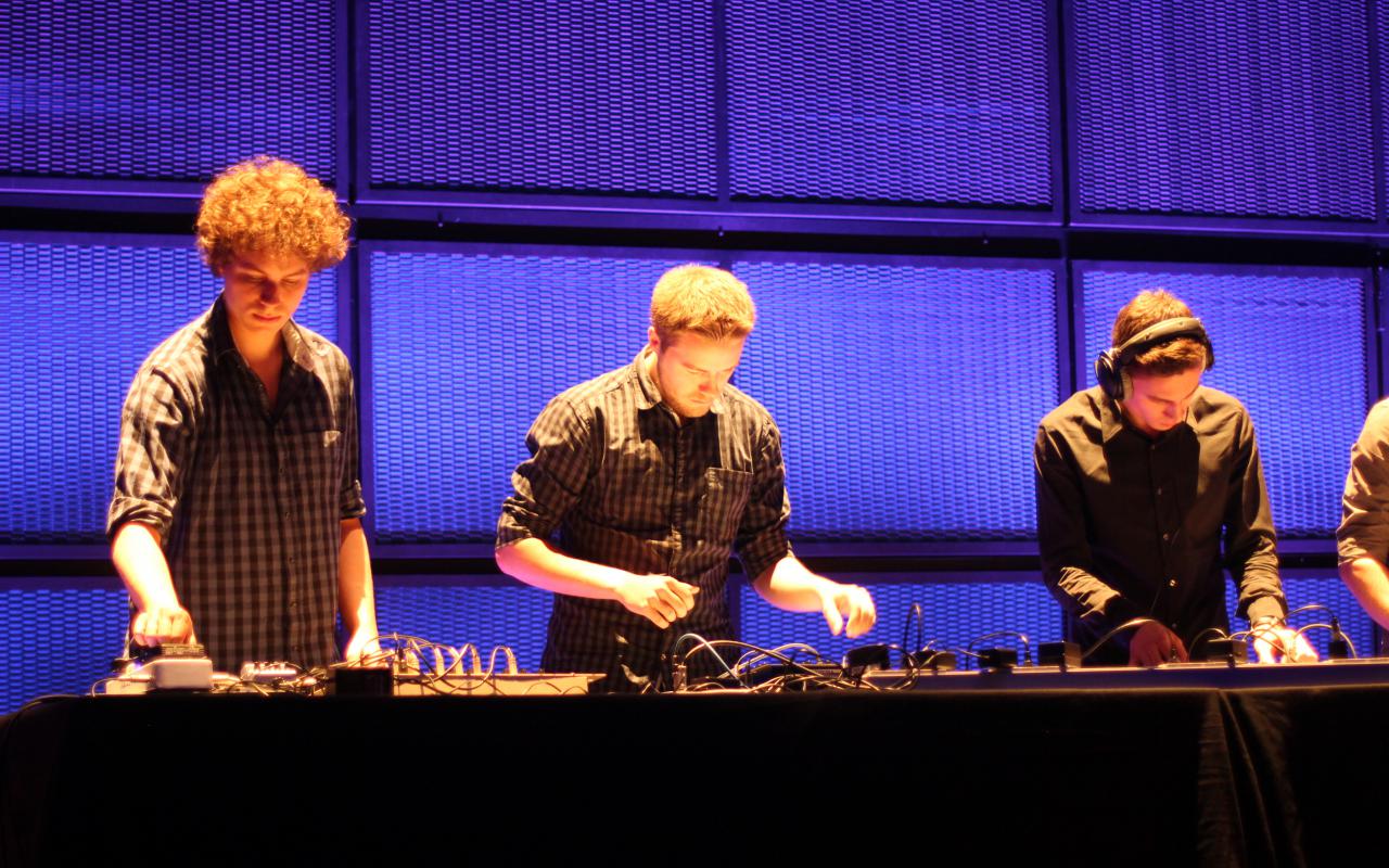 3 persons on stage at turntables